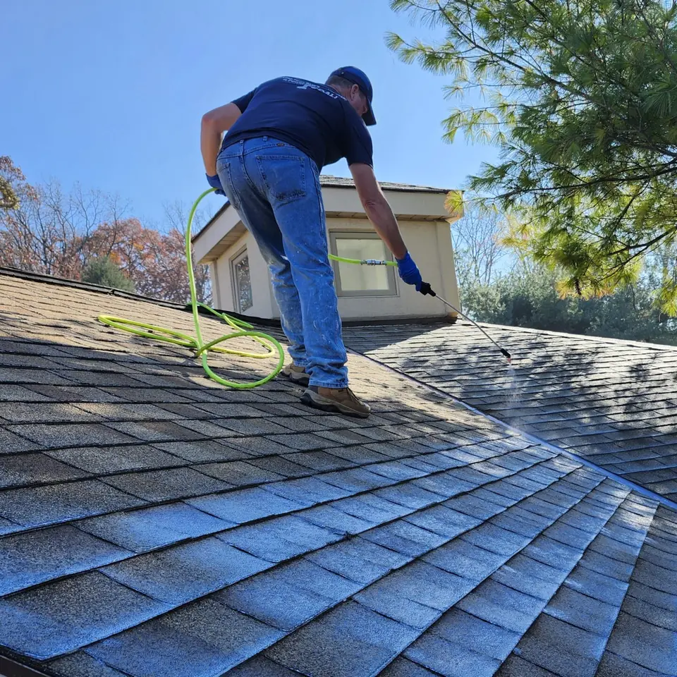 Spraying SoyFuze soy oil roof treatment on an asphalt shingle roof