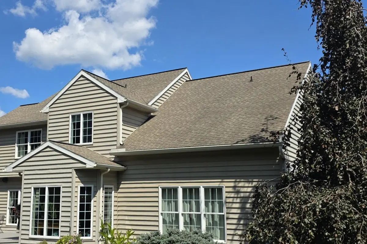 Faded dry asphalt shingle roof on a two-story house before SoyFuze treatment