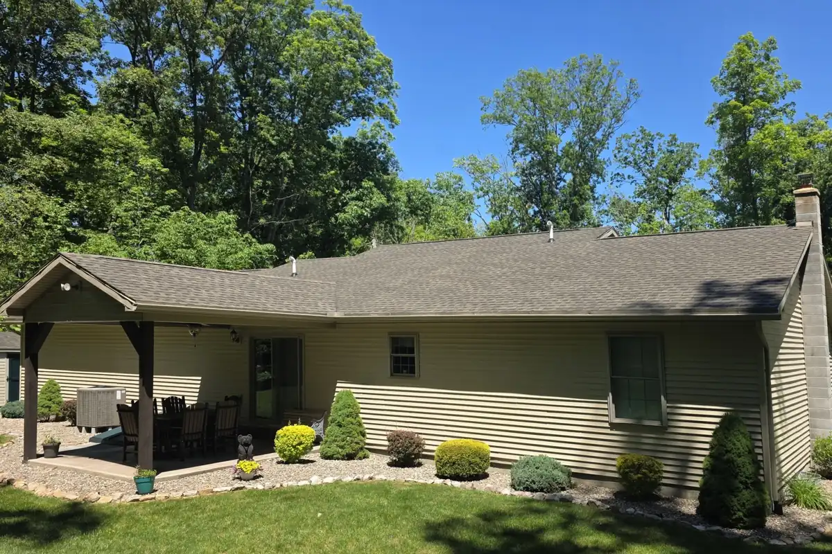Same ranch house with covered patio after SoyFuze soy oil roof treatment, with a darker, even shingle roof