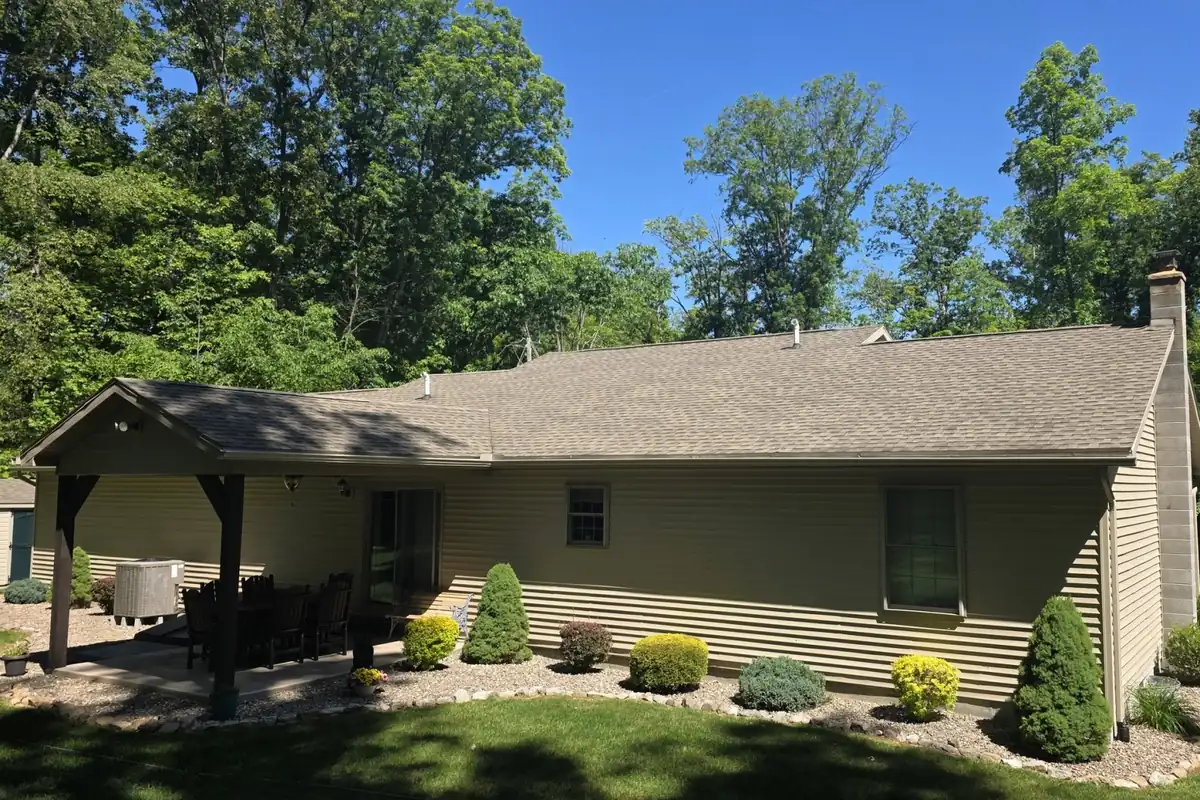 Weathered tan-gray asphalt shingle roof on a ranch house with a covered rear patio before soy oil roof treatment