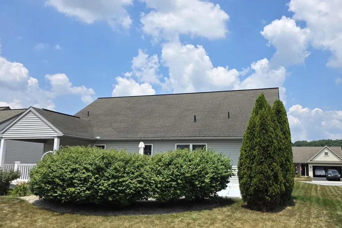 Same single-story house after SoyFuze soy oil roof treatment, with darker, uniform gray shingles